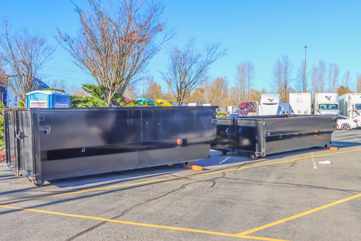 Professional dumpster rental service with roll-off container on residential driveway in Minden